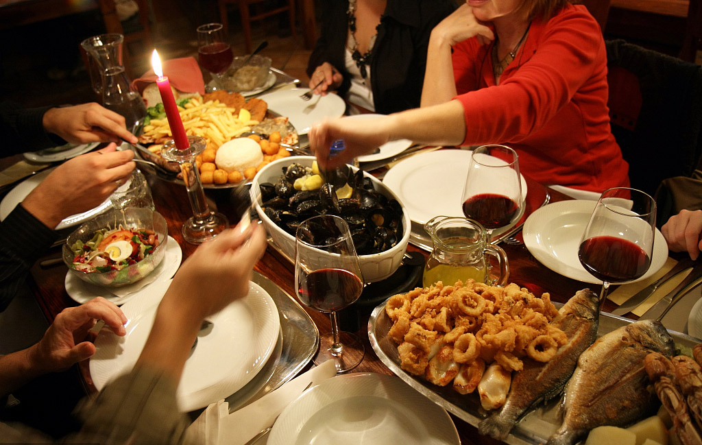 the whole family sits around the table enjoying their dinner