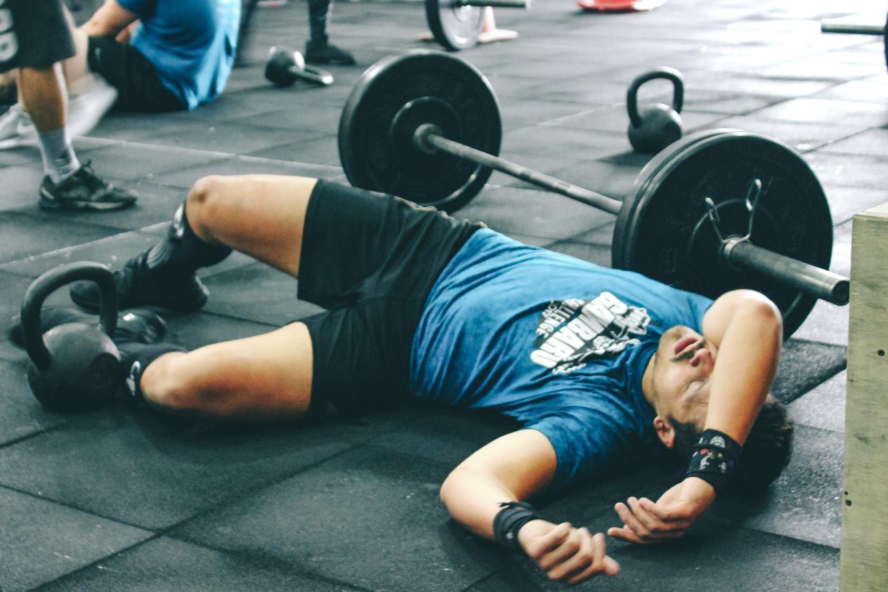 a man exhausted lies on gym floor